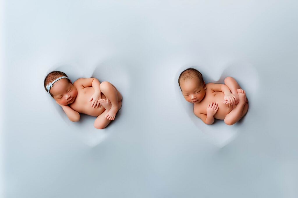 Twin boy girl newborns in heart bowls taken at NicSo Studio Charlotte Newborn Photography Studio.