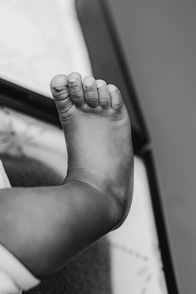 Black and white close-up of a premature newborn’s tiny foot during a Charlotte newborn photography session at NicSo Studio, capturing soft wrinkles and delicate details.