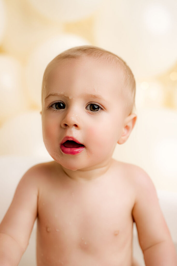 One year old baby boy after splash bath during cake smash session at luxury portrait studio