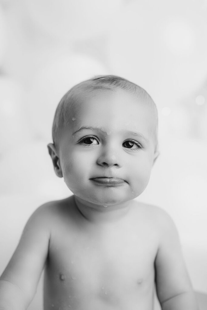 Black and white milestone portrait of one year old baby boy at NicSo Studio in Waxhaw NC