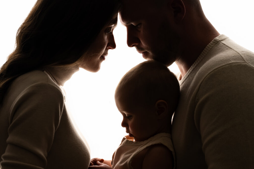 One year milestone silhouette portrait recreating newborn session with mom dad and baby boy